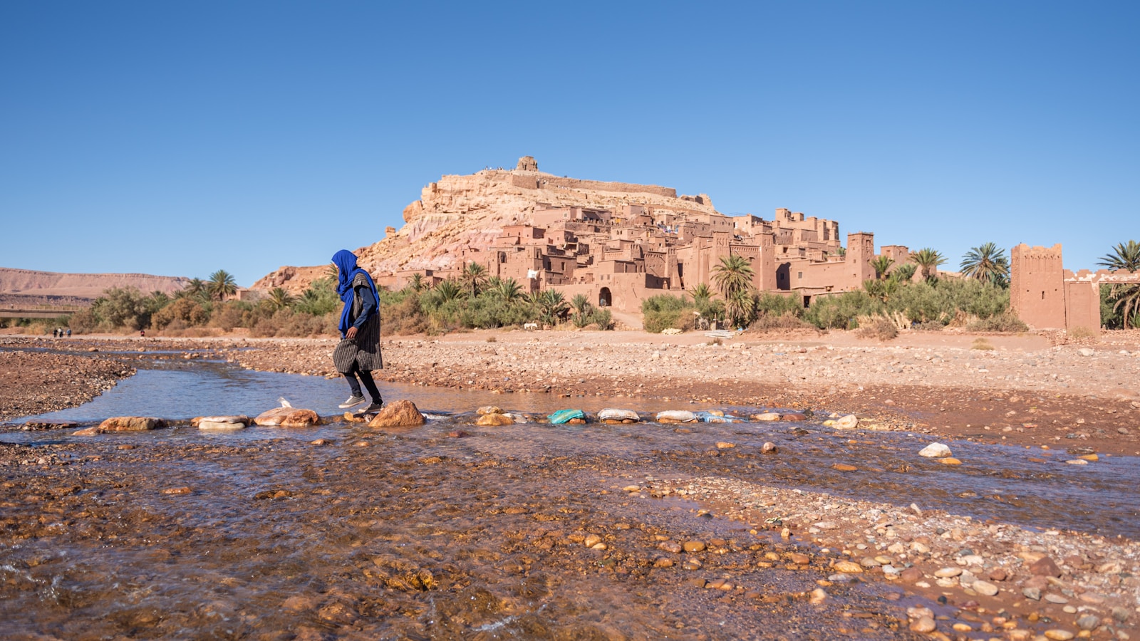 A man standing in a muddy field next to a building